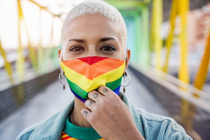 Young woman wearing gay pride mask