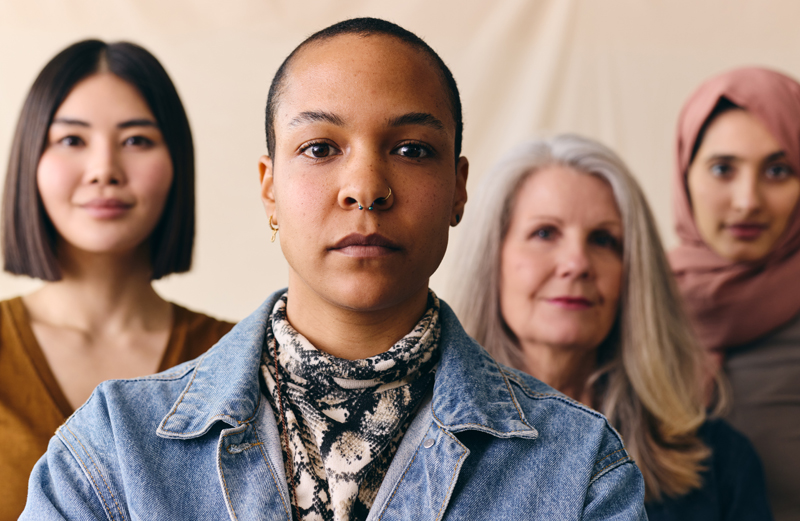 Mid adult mixed race LGBTQ woman in front of group